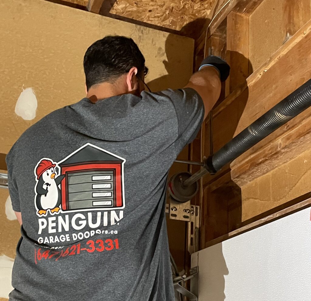 Penguin Garage Doors technician repairing a residential garage door in Richmond Hill, delivering expert, affordable, and reliable garage door repair services.